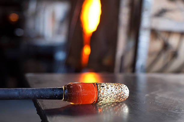 Molten glass being shaped into a drinking goblet stock photo