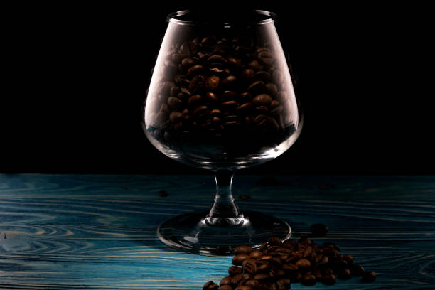 istock Coffee beans in a glass on a blue wooden table. 1380126675