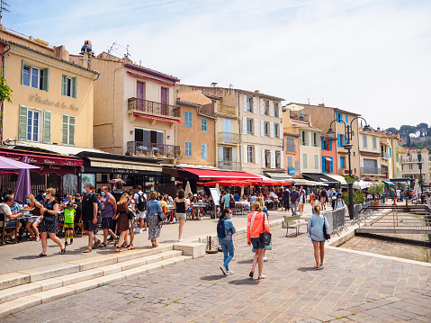 On May 2021, tourists were walking or having lunch in the restaurants of Cassis Harbor in the south of France.