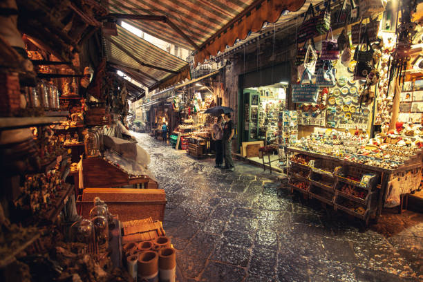 Naples, Italy, June 11, 2011: People sheltering from a summer storm and rain in the small shops of San Gregorio Armeno, on June 6, 2011 in Napoli, Italy. San Gregorio Armeno is a neighborhood characterized by small artisanal shops selling presepe and all kind of hand made miniatures.