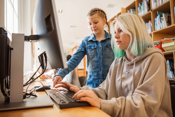 istock Two beautiful female sister students studying in a public library 1380155401