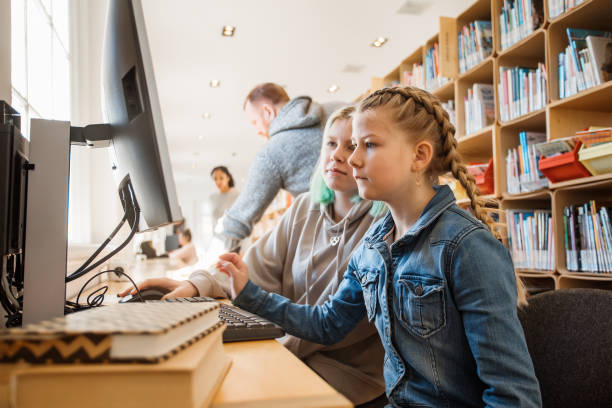 Two beautiful female sister students studying in a public library