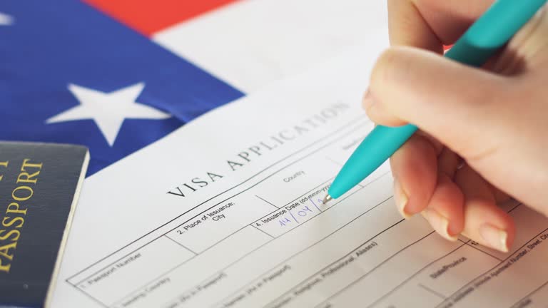 Woman filling visa application form. American flag on the background. Immigration to USA.