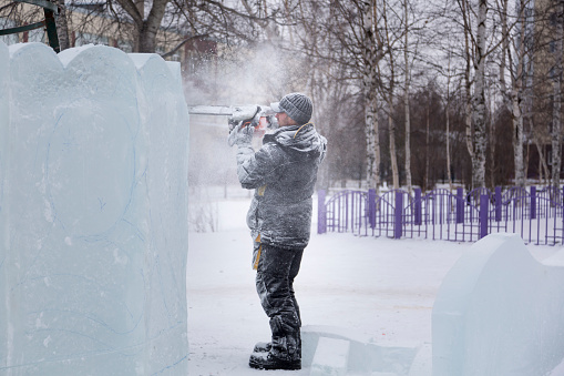 The sculptor carves a graceful composition on the ice panel