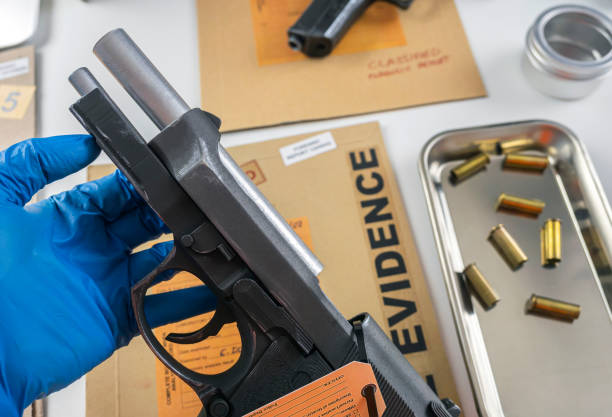 policial científico examinando vestígios de uma arma em laboratório balístico - csi - fotografias e filmes do acervo