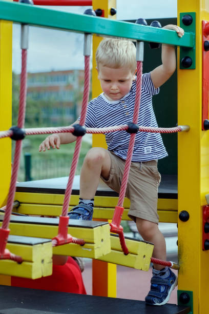istock A child learns to walk on a monkey bridge in a playground 1380170661