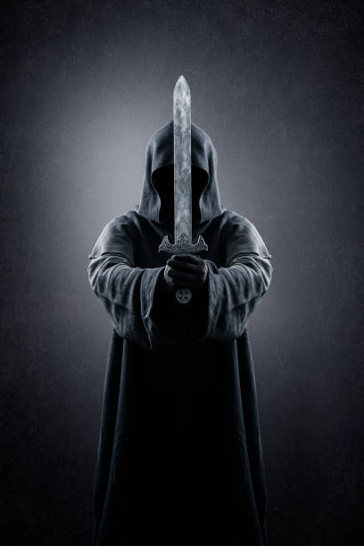 istock Warrior with hooded cape and medieval sword over dark misty background 1380172793