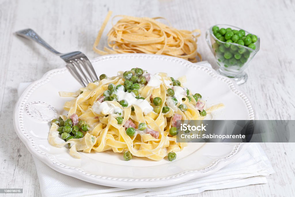 noodles with cream and ham Egg noodles with cream, ham and green peas Animal Egg Stock Photo