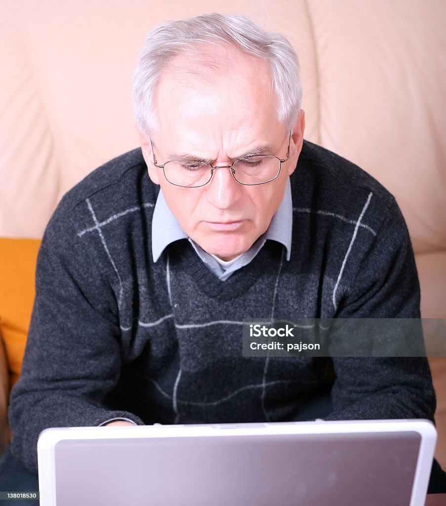 Starszy człowiek pisania na laptopa - Zbiór zdjęć royalty-free (Ból głowy)