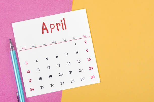 The April 2022 calendar  with pen on multicolored background.