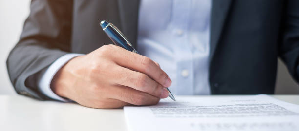 istock man signing on contract documents after reading, man holding pen and approve on business report. Contract agreement, law and deal concepts 1380191043