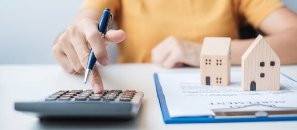 istock Woman using calculator during signing home contract documents. Contract agreement, real estate,  buy and sale and insurance concepts 1380195834