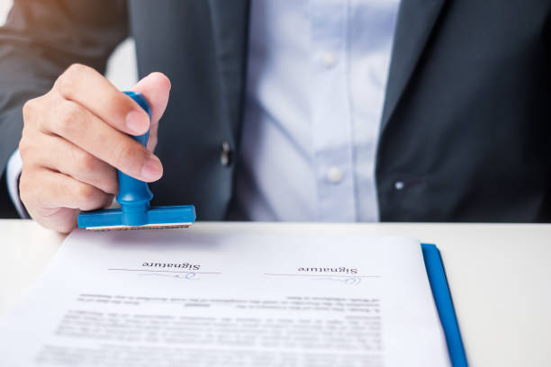 istock Businessman stamp during signing contract document.Business contract, approve, partnership, contract agreement and quality assurance concepts 1380196377