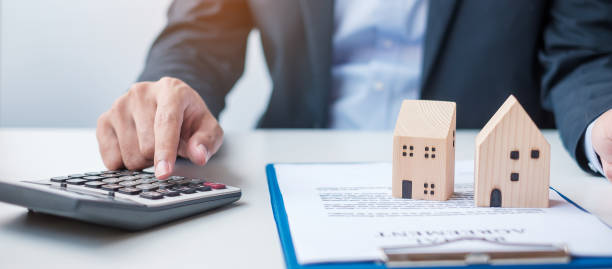 istock man using calculator during signing home contract documents. Contract agreement, real estate,  buy and sale and insurance concepts 1380196883