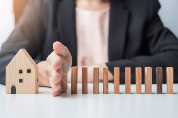 istock Businessman stop falling wooden blocks and protect house model. Crisis, fall Business, Risk, Economic recession, Developer, Real Estate and Property concept 1380200549