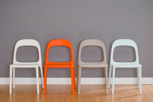 Four modern plastic chairs in austere space. This is part of a series with 1, 2 3 and 4 chairs.