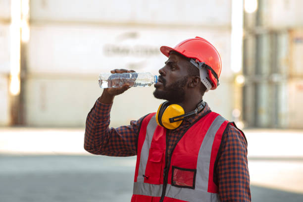 istock African american man worker drinking water and resting after working at container yard. 1380204733