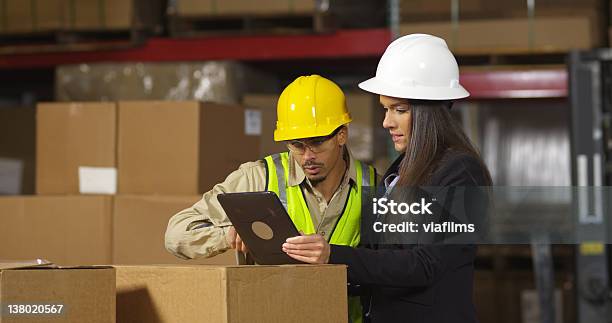 Os Trabalhadores Da Indústria Usando Tablet Digital No Armazém De Envio - Fotografias de stock e mais imagens de Capacete