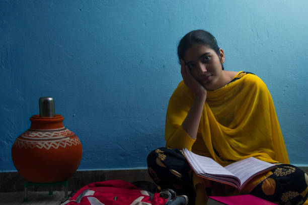 istock A girl in school uniform thinking while studying at home 1380222740