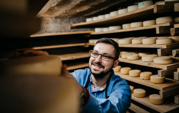 istock Man with cheese wheels at the storage 1380226377