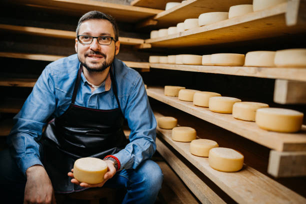istock Man with cheese wheels at the storage 1380226901