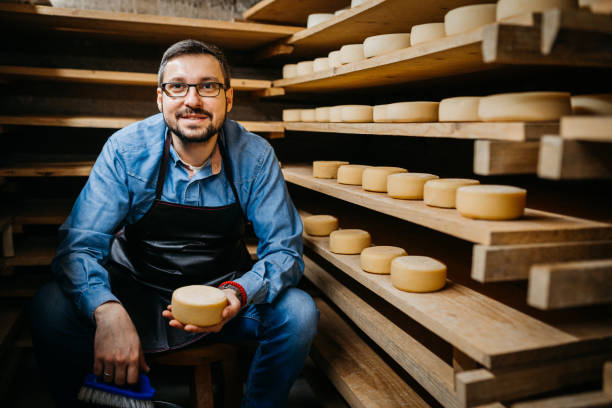 istock Man with cheese wheels at the storage 1380226903