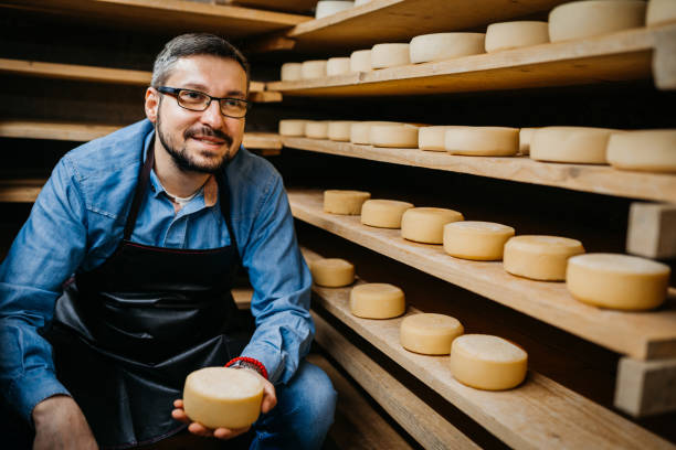 istock Man with cheese wheels at the storage 1380227429
