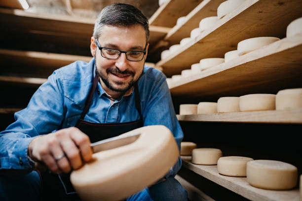 istock Man with cheese wheels at the storage 1380228990