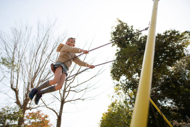 Girl playing on a swing in the park