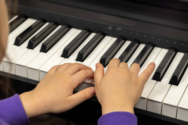 子供の指とピアノを弾くピアノのキーに選択的に焦点を当てます。コンサートや音楽教育のための楽器。 - piano keyboard instrument one person piano key ストックフォトと画像