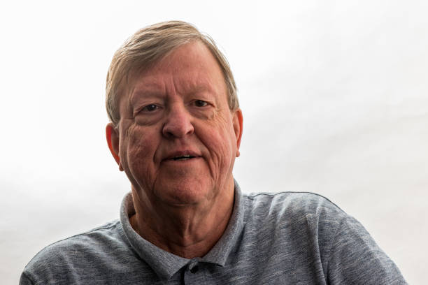 A Portrait of retired senior man standing at home.