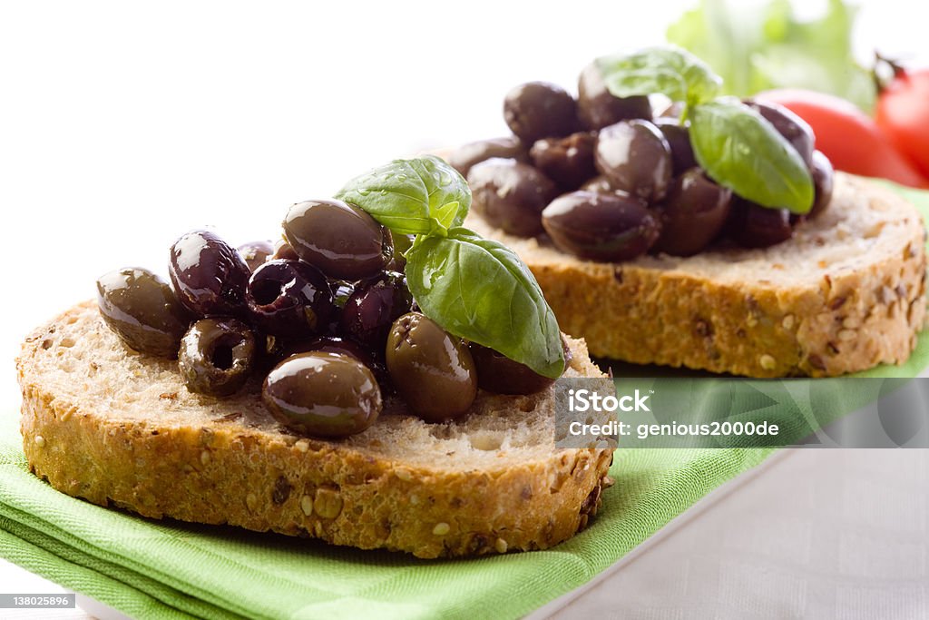 Bruschetta with olives photo of delicious sliced bread with olives and basil Appetizer Stock Photo