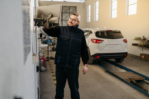 istock Happy auto repairman working on touchpad in a worksho 1380265468