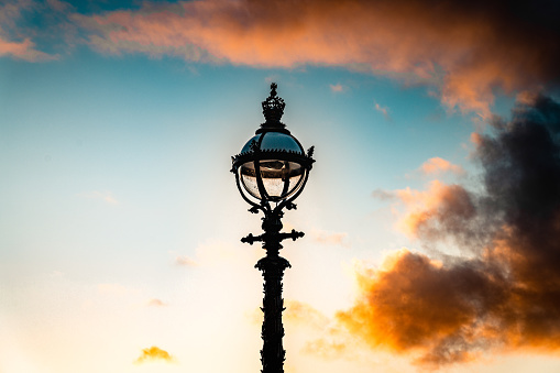 Old vintage lantern lamp post on the sunset sky background