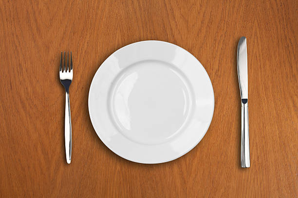 istock wite plate, fork and knife on wooden table 138028304