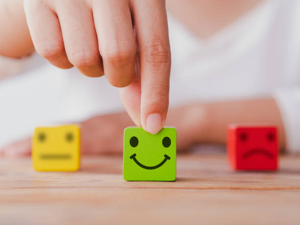 istock Customer service satisfaction survey concept. Customer hand choose happy smiley face, blurred neutral and sad face icon on wood cube to survey feedback, business, rating, review, service satisfaction. 1380283527