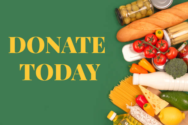 Different groceries, food donations on green background with copyspace - pasta, fresh vegatables, canned food, baguette, cooking oil, tomatoes, cheese. Food donations, food bank, food delivery concept