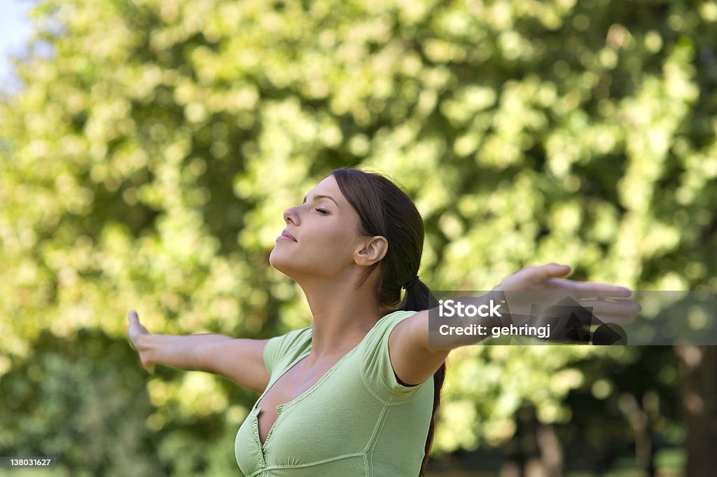 Beautiful young woman in the park Beautiful young woman in the park, arms outstretched 20-24 Years Stock Photo