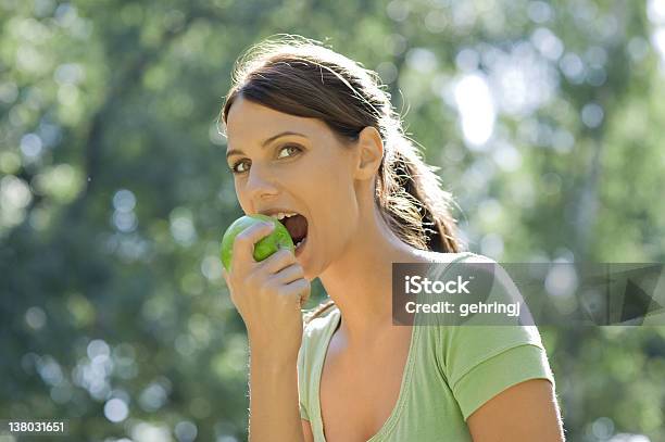 Beautiful Young Woman Eating Apple In The Park Stock Photo - Download Image Now - Apple - Fruit, Biting, Eating