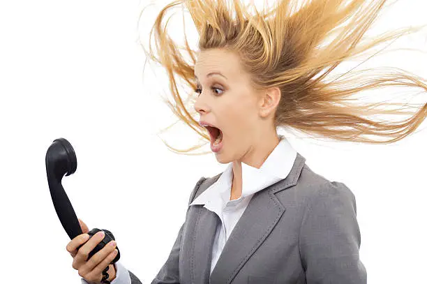 Surprised businesswoman with telephone. Isolated on white background.