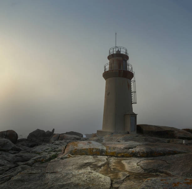 Lighthouse on the rocks  of Costa da Morte. stock photo