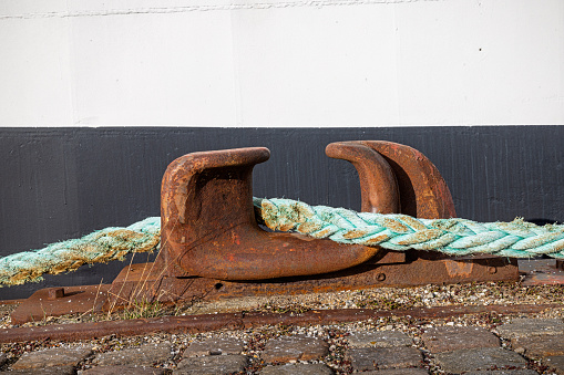 Rope and bollard at a pier in a part of Copenhagen harbor which are utilized for house boats