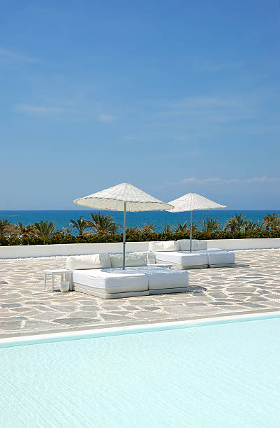 istock Swimming pool and white sunbeds at ultra modern luxury hotel 138033267