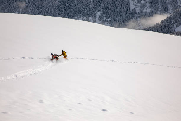 istock Two snowboarders riding together in a fresh powder snow 1380338603