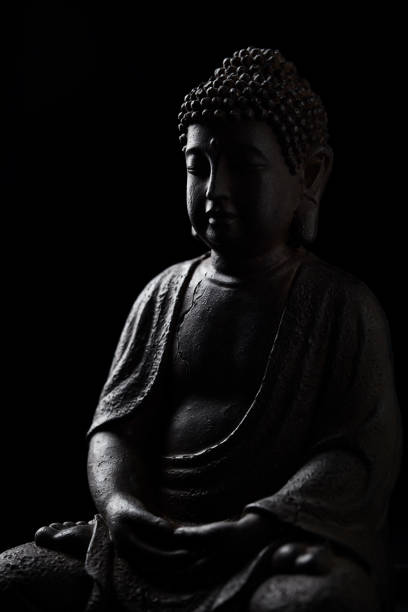 istock Meditating Buddha Statue isolated on black background. Selective focus. Close up. 1380365803