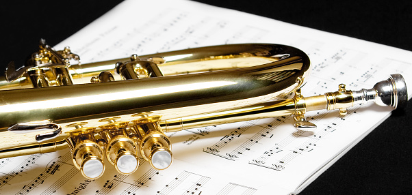 Gold plated flugelhorn on top of music sheet