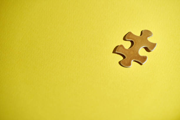 istock gold colored jigsaw puzzle against yellow background 1380394441