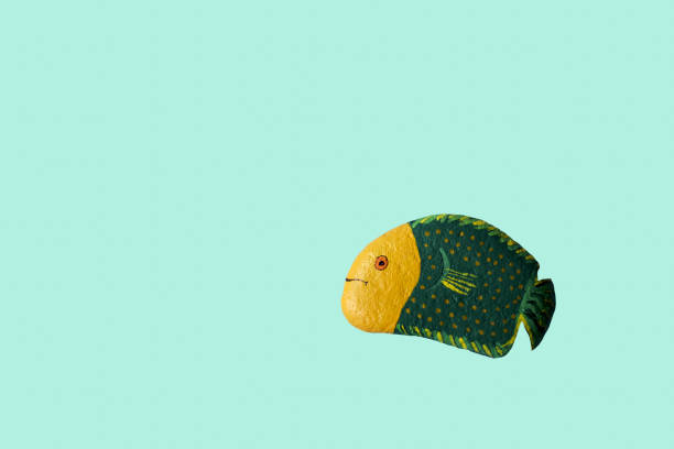 homemade painted stone in the shape of fish, copy space