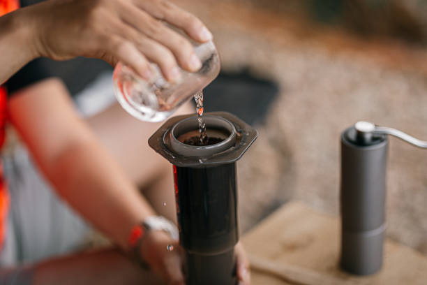 Asian Barista is using a manual coffee maker press to make coffee\nAeropress