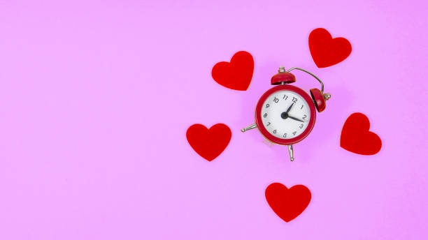 istock Felt hearts and alarm clock with copyspace for 8 march womens day love on purple violet background 1380436436